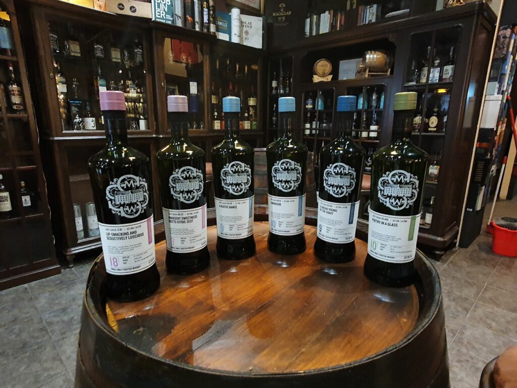 Botellas de whisky la SMWS encima de un barril